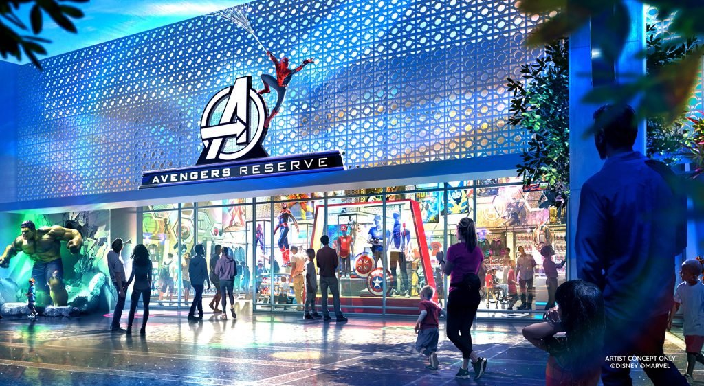 Concept art of the Avengers Reserve building, featuring a large Avengers logo above the entrance, Spider-Man swinging on a web, and a Hulk statue on the left. Visitors are seen entering and observing the attraction.