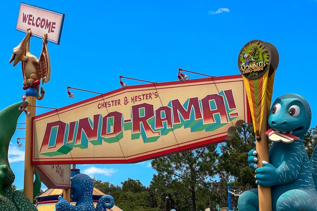 "Chester & Hester's DIN-O-RAMA!" entrance sign with a dinosaur figure and a "Welcome" sign above it.