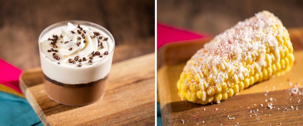 A dessert cup with layers of chocolate mousse and whipped cream, topped with chocolate nibs, next to a piece of corn on the cob covered in cheese and seasoning.
