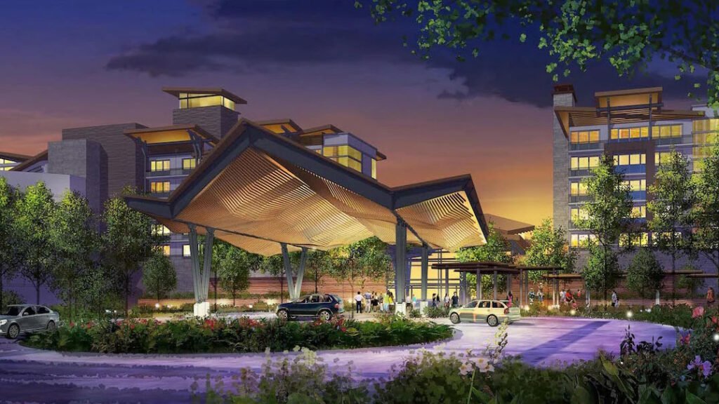 Architectural rendering of a building entrance at dusk, featuring a large, modern canopy supported by pillars, surrounded by landscaped greenery and a circular driveway with cars and people.