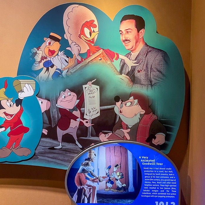 A display featuring classic animated characters and a man interacting with them, alongside a plaque describing "A Very Animated Goodwill Tour" with historical context and images from a related animated film.