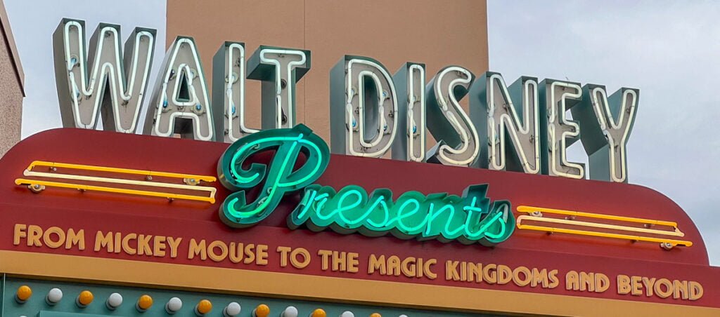 Walt Disney Presents sign with neon lights that reads "FROM MICKEY MOUSE TO THE MAGIC KINGDOMS AND BEYOND."