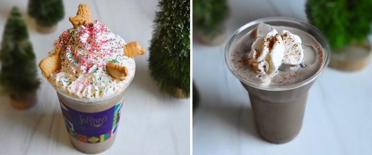Two beverages in clear cups with festive toppings: the left cup features whipped cream, colorful sprinkles, and cookie pieces, while the right cup contains whipped cream and a dusting of spice, set against small green decorative trees.