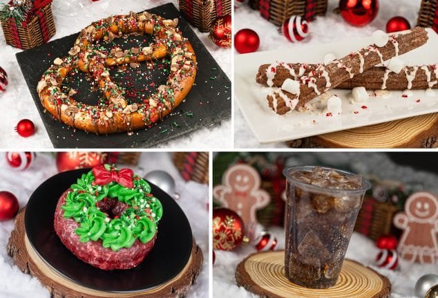 A festive display of holiday-themed treats including a large pretzel topped with colorful sprinkles, chocolate sticks drizzled with icing, a green and red wreath donut, and a cup of soda with ice, all set against a backdrop of Christmas decorations.
