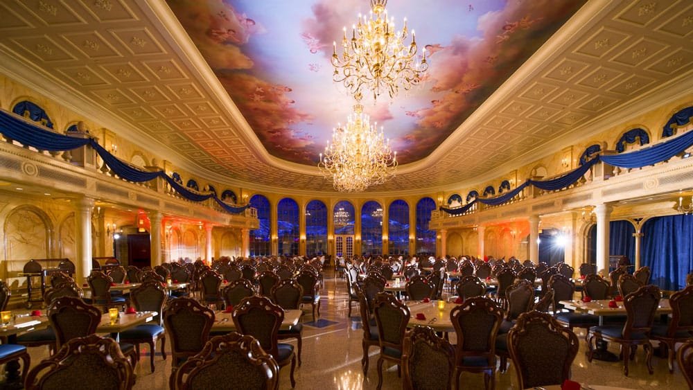 An elegant dining room featuring ornate chairs and tables, a grand chandelier, and a painted ceiling with clouds, set in a luxurious space illuminated with warm and cool lighting.