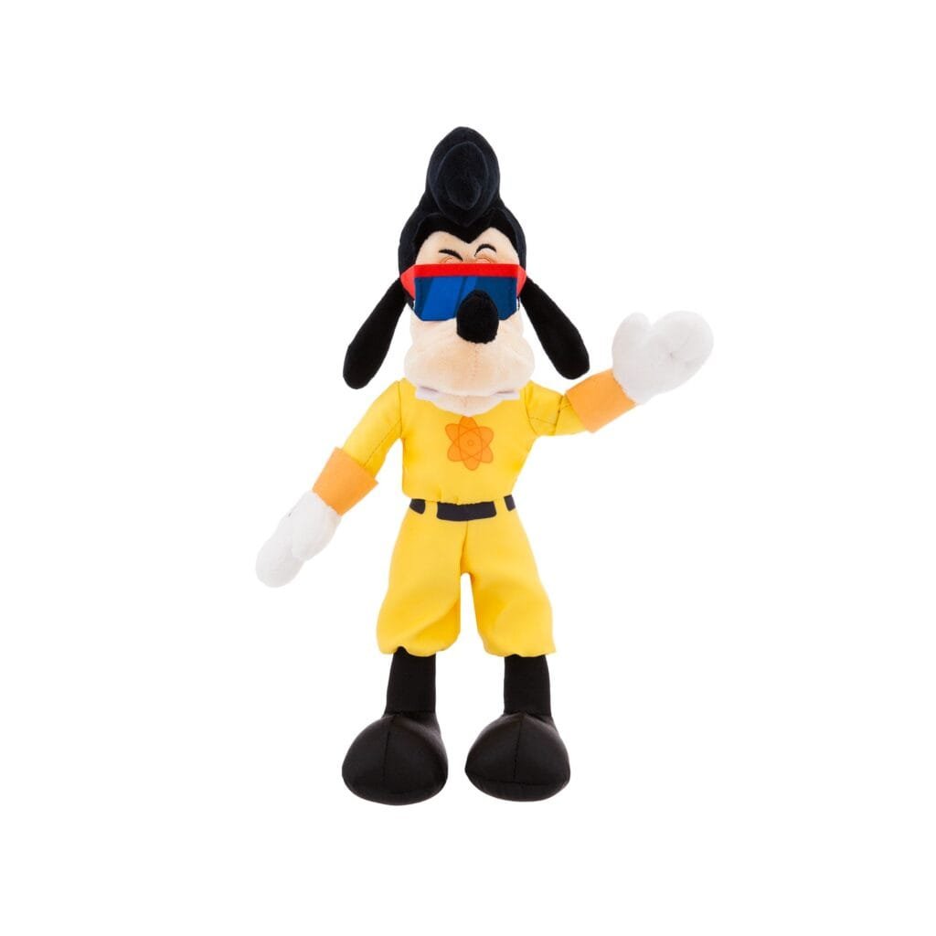 A plush toy of a cartoon character resembling a dog, wearing yellow attire with an orange atomic symbol, sunglasses, and a black hairstyle, waving one hand.